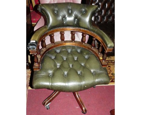 A contemporary mahogany framed green leather buttoned upholstered and further studded tub swivel desk chair (some damage to u