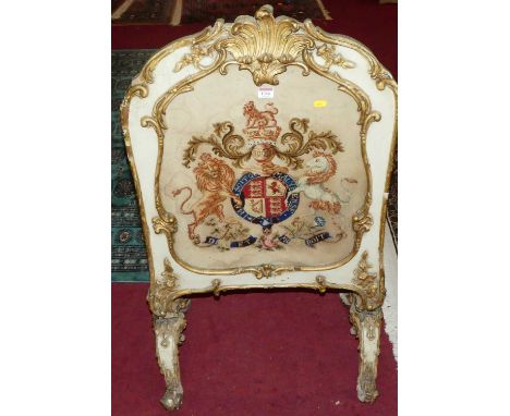 A 19th century white painted and giltwood framed firescreen, in the Rococo taste, having an embroidered inset coat of arms (s