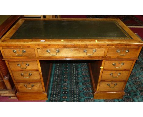 A circa 1900 rosewood and burr oak crossbanded twin pedestal writing desk, having a gilt tooled green leather inset writing s