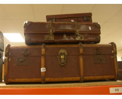 A wooden bound canvas trunk and two suitcases.