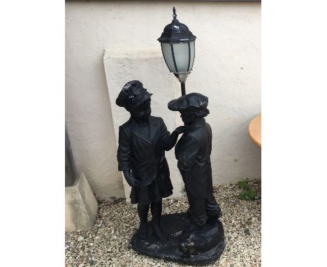 A resin garden light ornament in the form of a boy and a girl