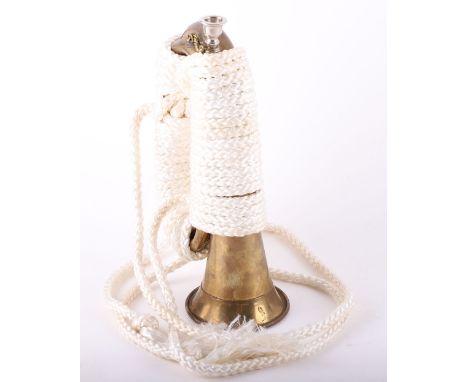 Brass British Military Style Bugle, complete with its white metal mouth piece. Thick white platted rope tie around the body o
