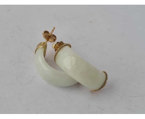 A pair of 9ct marked jade earrings each carved in a semi circular shape.
