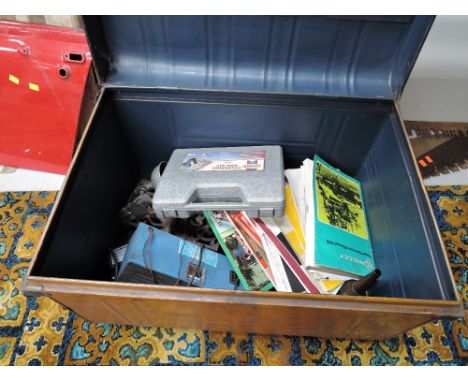 A vintage tin trunk containing various MG Manuals and workshop tools