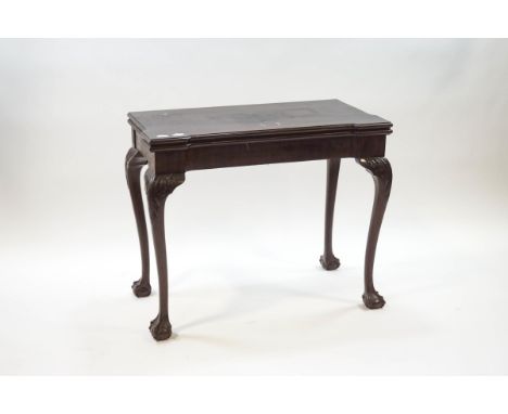 A George III style mahogany card table, the fold over top enclosing a brown baize surface, on acanthus carved legs and claw a