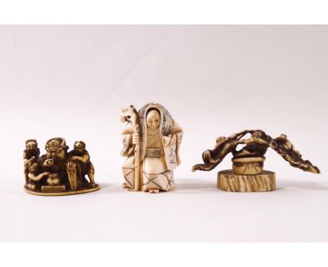 An early 20th century Japanese ivory netsuke, carved as a wise old man with rotating double face, signed, and two further net