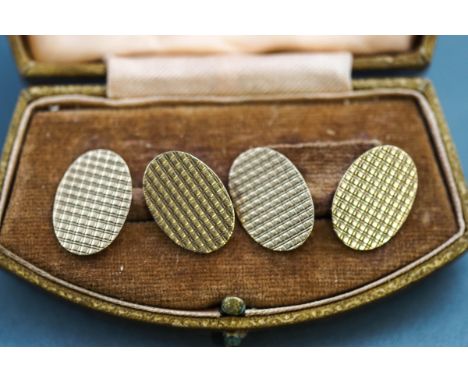 A boxed pair of hallmarked 9 carat gold cufflinks. Double sided oval links with engine turned design. Hallmarked 9ct gold, Bi