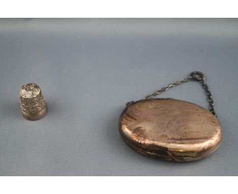 A Victorian oval silver purse with suspension chain, London 1881, together with a silver plated thimble