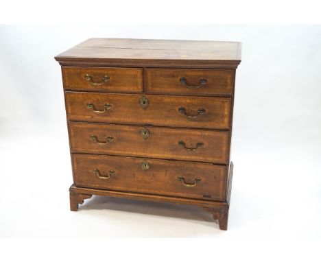 A George III oak and mahogany cross banded chest of two short and three long drawers with brass handles and bracket feet, 96c