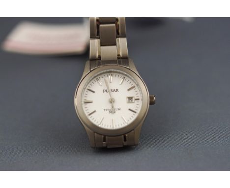 A Pulsar titanium lady's wristwatch. White baton dial with date feature. Titanium bracelet with fold over clasp. Case referen