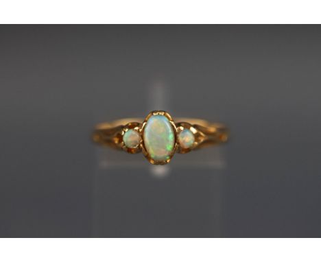 A yellow metal three stone opal ring. Test indicates 18ct. Gross weight: 2.5 grams