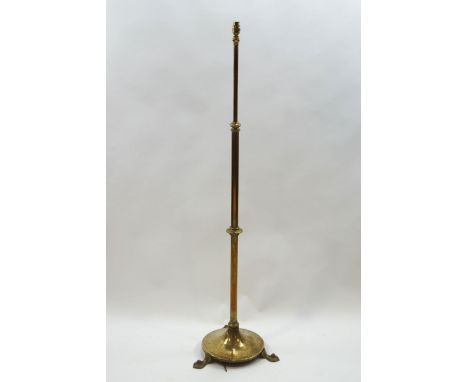 A brass telescopic standard lamp on round base, issuing to three Art Nouveau style feet, 131cm high