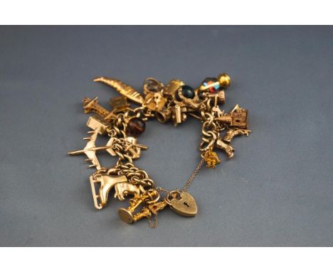 A hallmarked 9 carat gold curb bracelet with padlock and safety chain together with twenty five assorted charms. Gross weight