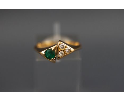 A yellow metal emerald and diamond dress ring, tests indicate 18ct gold. 3.7 grams boxed