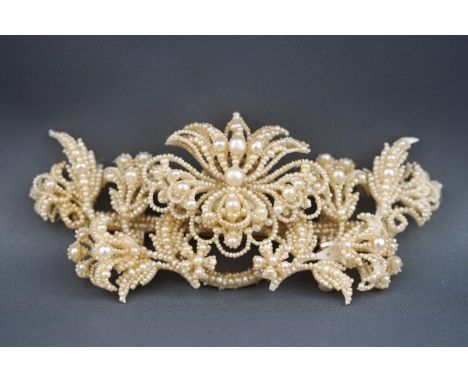 A seed pearl and mother of pearl backed brooch with yellow gold pin and hook fitting. Gross weight: 26.4 grams