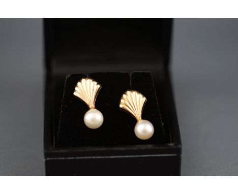 A pair of 9 carat gold and pearl stud earrings in the design of a shell. Cultured pearl measuring approximately 6.50mm, Post 
