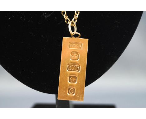 A hallmarked 9ct gold ingot pendant suspended from a belcher link chain, bolt ring clasp, 560mm. Gross weight: 39.7 grams