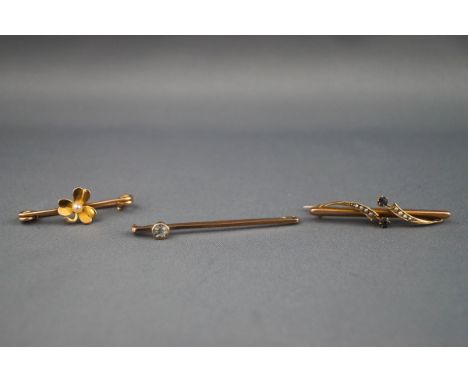 A collection of three bar brooches : One yellow metal bar brooch with central clover set with a seed pearl. Safety pin fittin