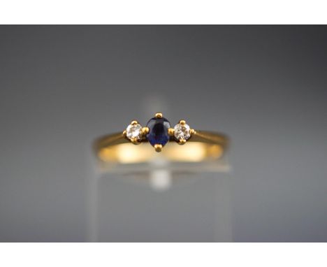 A hallmarked 18ct gold ring set with an oval sapphire measuring 3.6mm x 3.2mm together with two round diamonds measuring 2.2m