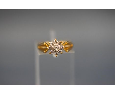 An 18 carat and diamond flowerhead cluster ring. Hallmarked 18ct, Birmingham, 1970. 3.8 grams boxed