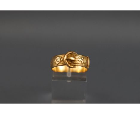 A hallmarked 18 carat gold buckle ring with engine turned design. Gross weight: 4.7 grams