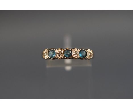 A seven stone ring set with blue topaz and diamonds, hallmarked 9ct, London, stamped 'DIA', 2.2 grams