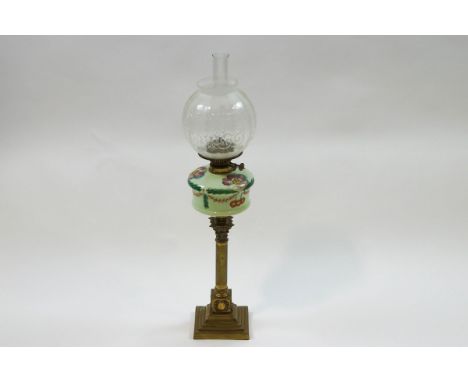 A Victorian brass Corinthian column oil lamp with painted glass reservoir and etched globe shade, 77cm high