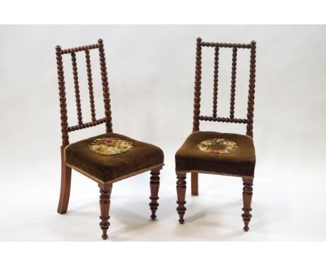 A pair of Victorian mahogany side chairs with bobbin turned backs, tapestry seats and turned tapering backs
