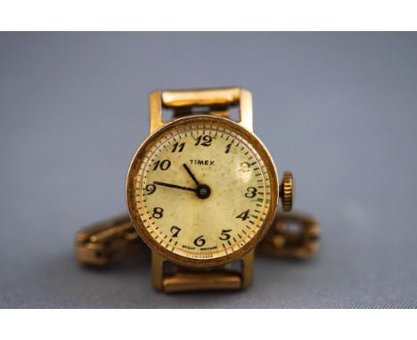 A ladies Timex wristwatch having a round full figure champagne dial with manual wind movement. Fitted with a hallmarked 9 car