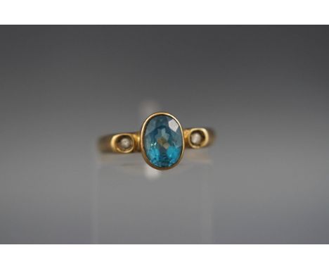 A three stone ring set with blue topaz and diamonds. hallmarked 9ct gold, London, 1989. 'A & G' 2.2 grams