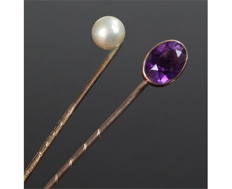 Two gold stick pins.One set an oval facetted amethyst, the other mounted with a pearl