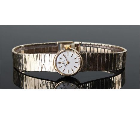 Omega 9 carat gold ladies wristwatch. The signed white dial with gilt baton hours, bark effect 9 carat gold bracelet, manual 