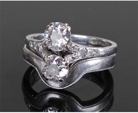 Two stone Art Deco style diamond ring. The round brilliant cut stones set vertically above one another with diamond chips to 