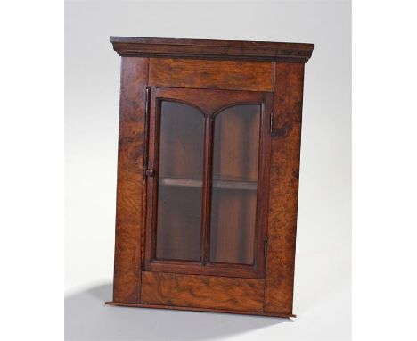 Walnut corner cabinet, of small proportions, the concave top above glazed door enclosing a shelf, 53cm high