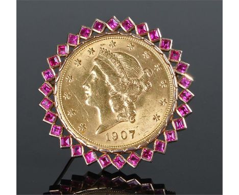 USA gold $20 brooch. The 1907 $20 coin with a square cut ruby surround containing thirty rubies, 45mm diameter