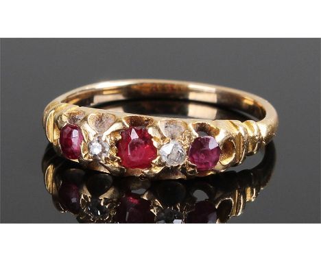 Yellow metal ruby and diamond ring, set with three rubies and two diamonds, ring size K