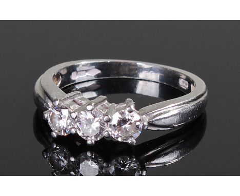 Platinum and diamond set ring, the ring set with three diamonds and wide shoulders, ring size K 1/2