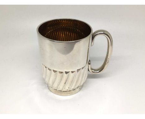 Edwardian gilt-lined silver mug, of cylindrical form with fluting to the bottom half, loop handle, 8cm high, London 1902 (Wil