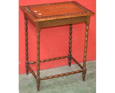 An oak occasional table, rectangular top, border carved in relief, bobbin turned legs and stretchers.