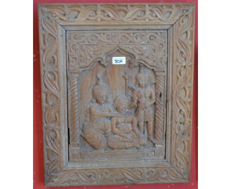An Indian hardwood architectural fragment, the central panel carved with a deity and attendants, scrolling leaf border, 53.5c