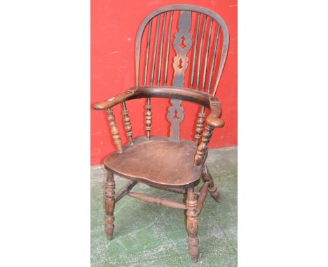 A Victorian elm and ash spindle back Windsor chair, pierced splat, outswept armrail, saddle seat, turned supports and double 