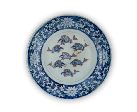 A very large blue and white and underglaze copper red 'fish' dishQing dynasty, Kangxi periodPainted to the central roundel wi