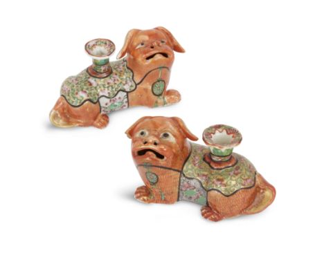 A pair of Chinese Canton famille rose 'lion' candle holdersQing dynasty, late 19th centuryModelled as recumbent coral-glazed 