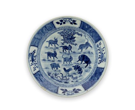 A large Chinese blue and white 'animals of the zodiac' dishQing dynasty, 19th century, apocryphal Kangxi markPainted in a cen