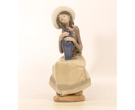 Nao Figure of a Woman clutching a blue potted vase. Height: 26.5cm 