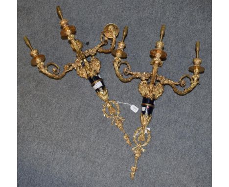 A pair of impressive three-light gilt-metal wall sconces, each issuing three leaf-cast arms over a Classical maiden mask, fla