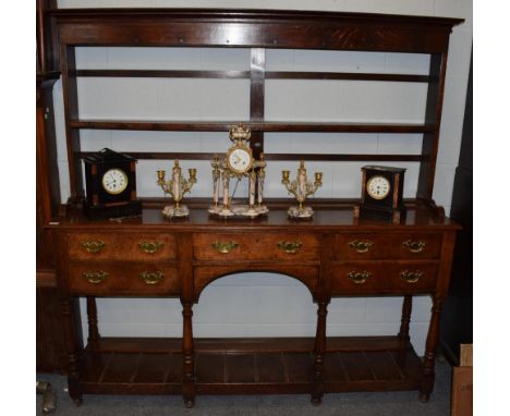 A George III oak open dresser, late 18th century, the rack with moulded pediment above a shelf, the base with five frieze dra