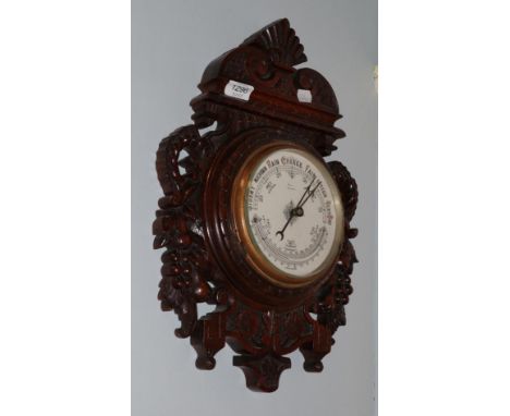 An Edwardian carved oak cased aneroid barometer 