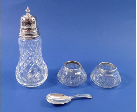 A pair of silver rimmed and cut glass salts, Chester 1925, a silver caddy spoon, London 1973, 19g plus a silver topped cut gl