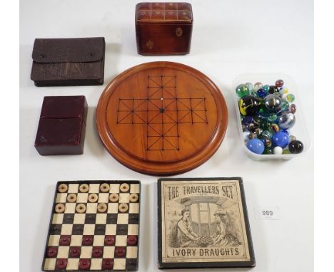 A Victorian boxed travellers set of simulated ivory draughts, a leather playing card box, games board, various playing cards 